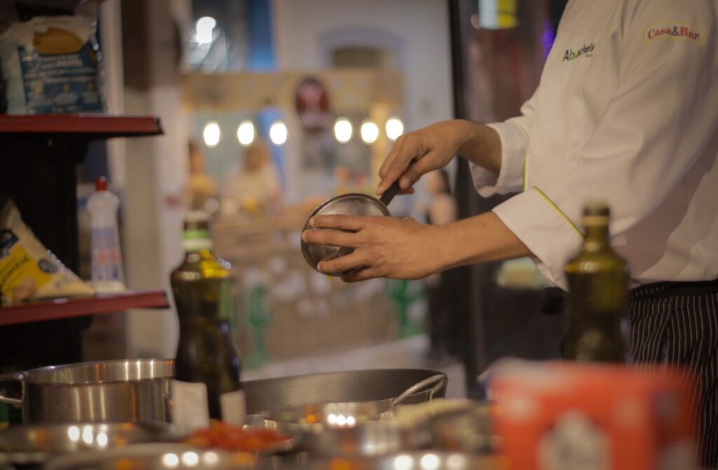 The Art of Drawing Readers In: Your attractive post title goes here A chef carefully preparing a meal in a warmly lit, cozy restaurant kitchen setting.