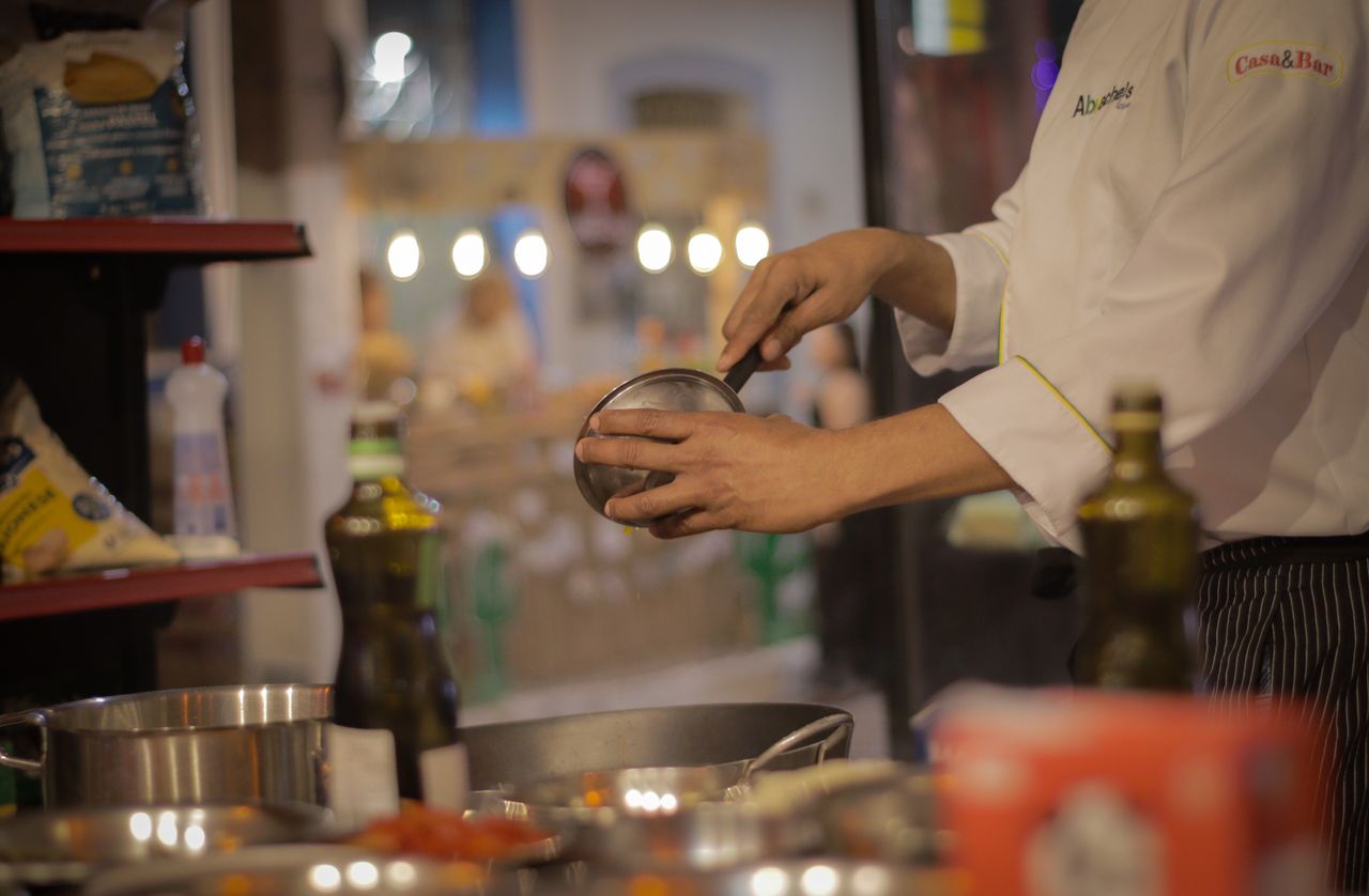 The Art of Drawing Readers In: Your attractive post title goes here A chef carefully preparing a meal in a warmly lit, cozy restaurant kitchen setting.