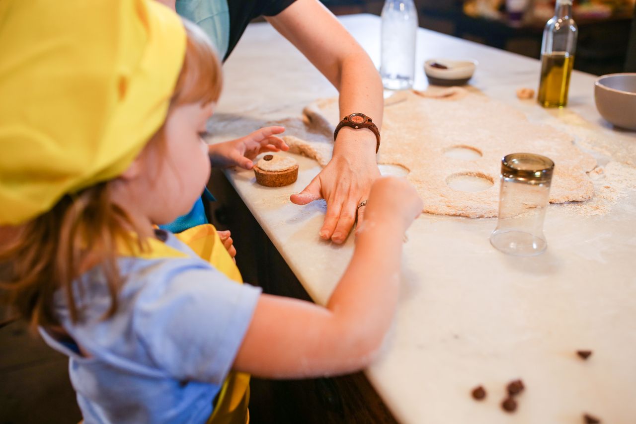 Crafting Captivating Headlines: Your awesome post title goes here A child and adult baking together, rolling dough on a kitchen counter with cookie cutters.